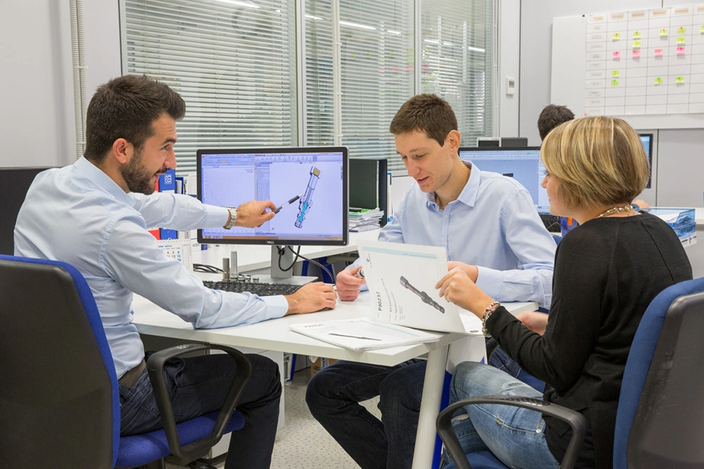 team guarda il computer e parla di una valvola oleodinamica